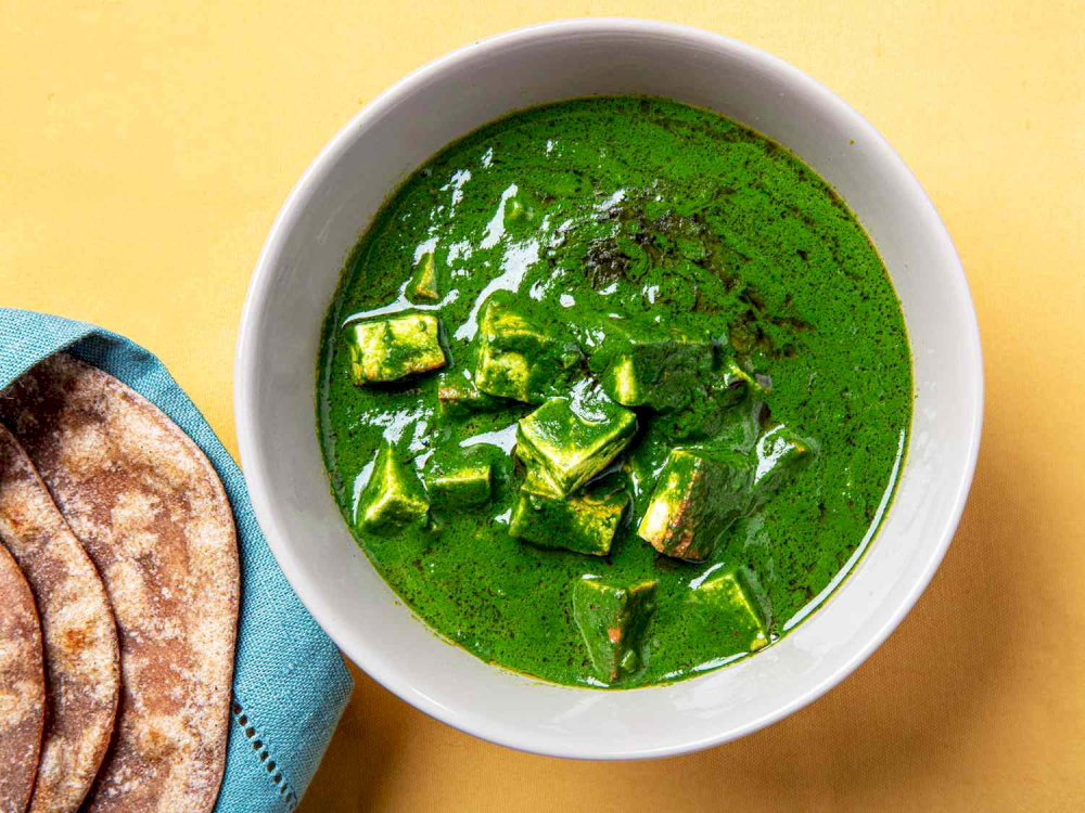 Palak paneer features soft cubes of paneer immersed in a creamy spinach gravy, creating a flavorful and comforting dish